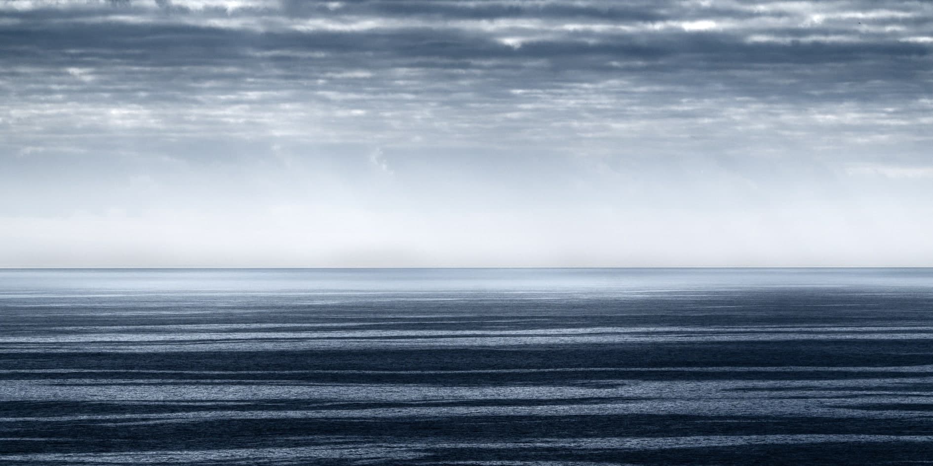 Mar azul oscuro con horizonte recto y cielo de nubes en franjas, minimalista. Agua #P32, fotografía de Cristian Letelier, edición limitada