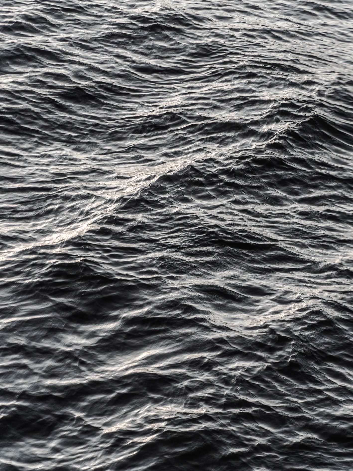 Vertical B/N: textura de olas del mar con reflejos en diagonal. Agua #P36, fotografía de Cristian Letelier, edición limitada