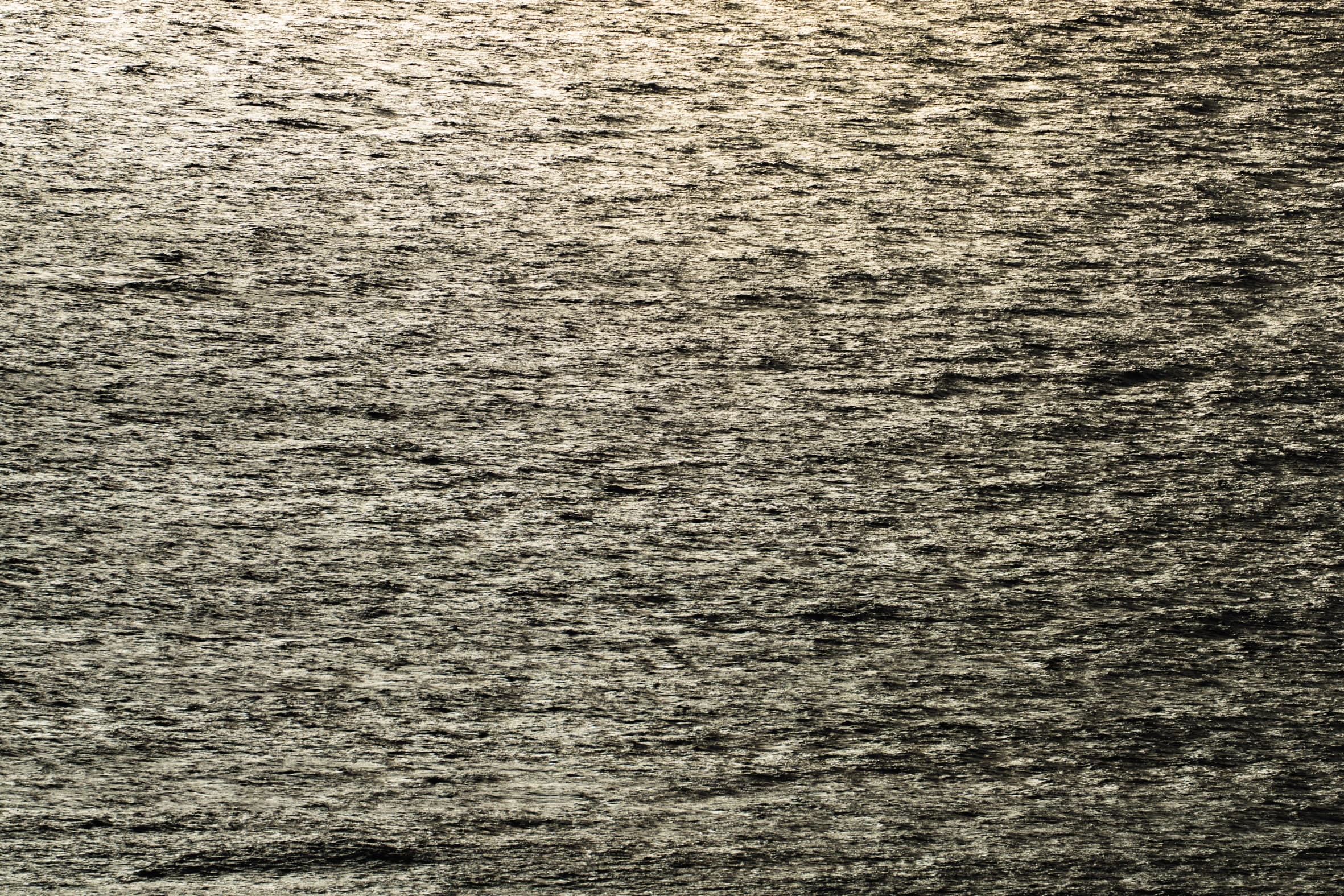 Superficie del mar en contraluz, reflejos plateados sobre agua oscura, sin horizonte. Agua #P41, fotografía de Cristian Letelier, edición limitada