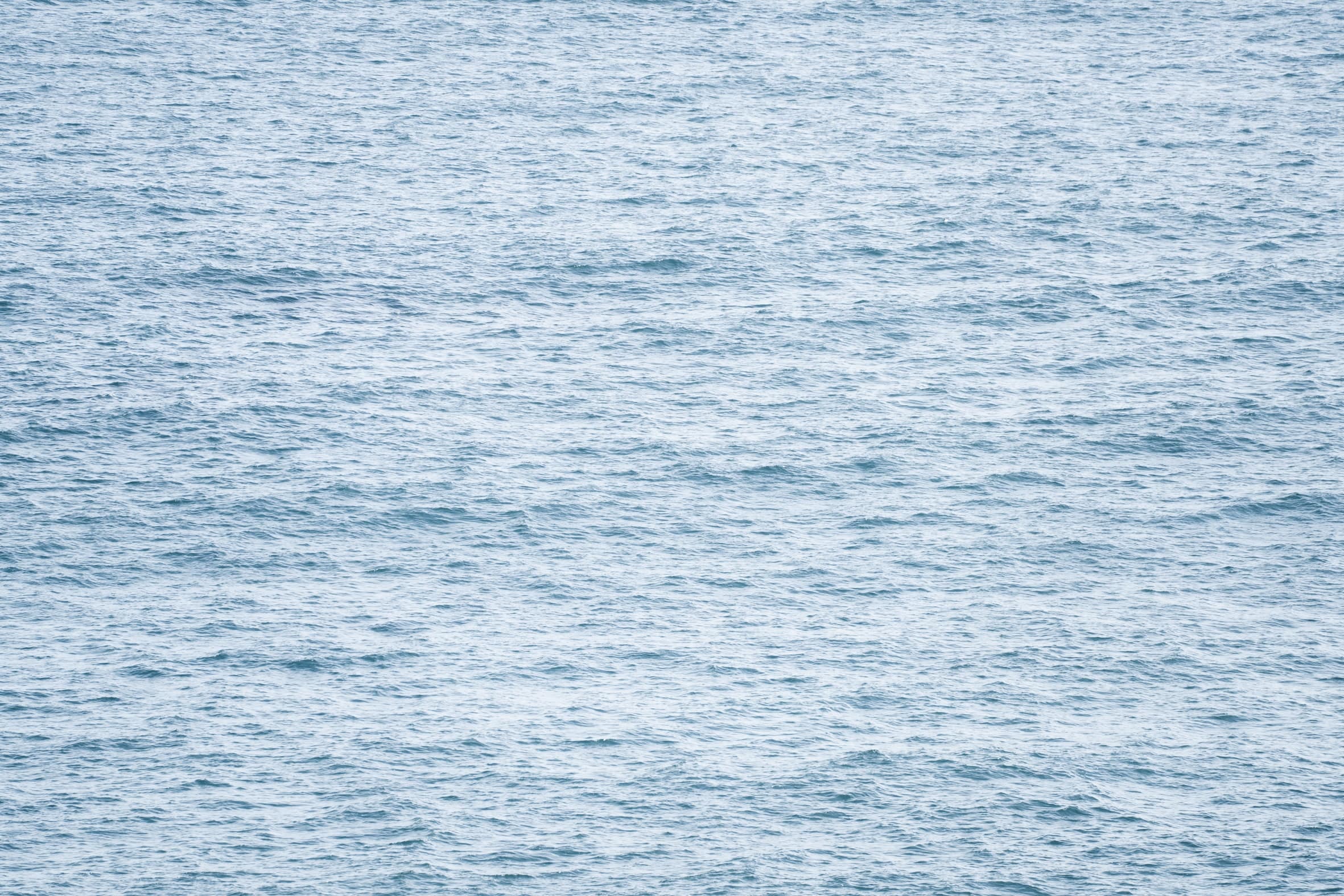 Superficie del mar azul pálido con oleaje fino, de cerca y sin horizonte. Agua #P42, fotografía de Cristian Letelier, edición limitada