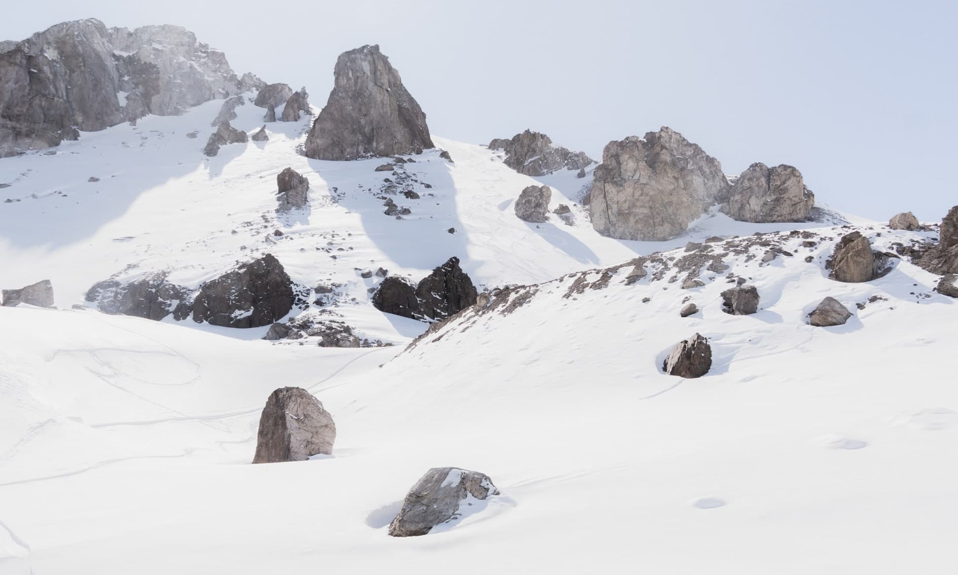 Grandes rocas dispersas sobre nieve, ladera con peñones, bruma blanca. Aire #C10, fotografía de Cristian Letelier, edición limitada