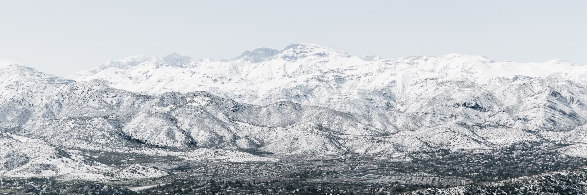 Panorámica 3x1 de cordón nevado con precordillera y valle al pie, tonos fríos. Aire #C11, fotografía de Cristian Letelier, edición limitada