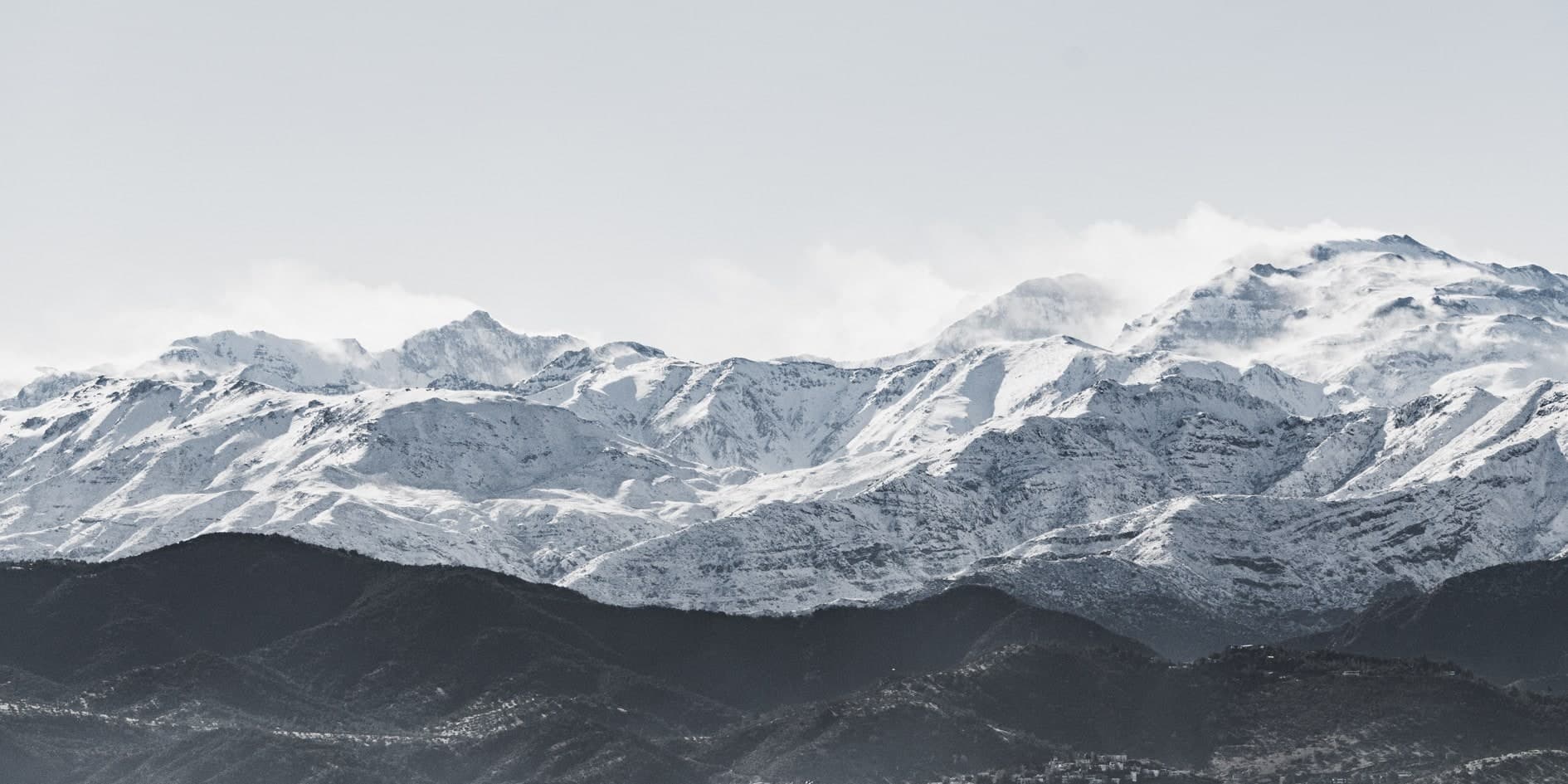 Cordillera nevada con nubes en las cumbres y cerros oscuros en primer plano. Aire #C15, fotografía de Cristian Letelier, edición limitada