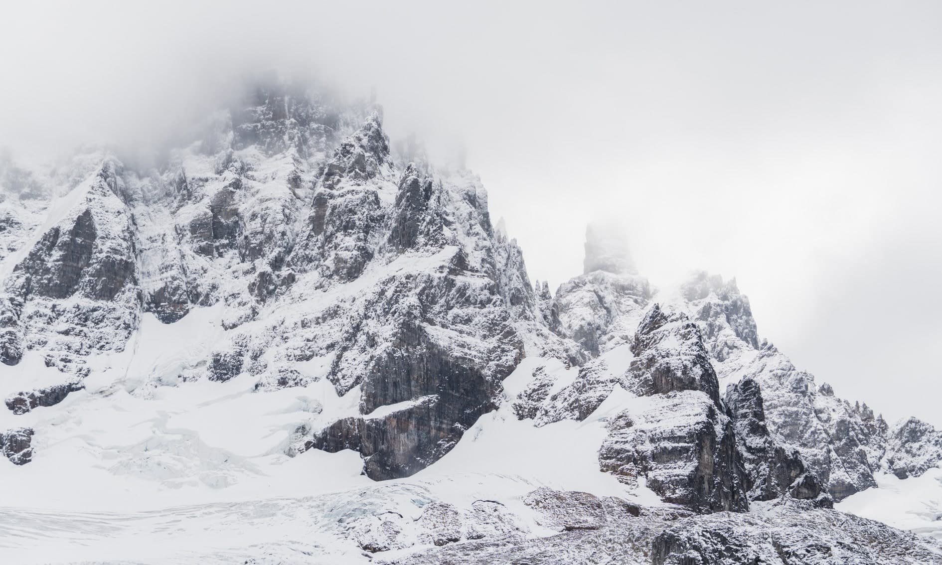 Paredes rocosas nevadas entre niebla, glaciar y hielo en la base, tonos grises. Aire #C5, fotografía de Cristian Letelier, edición limitada
