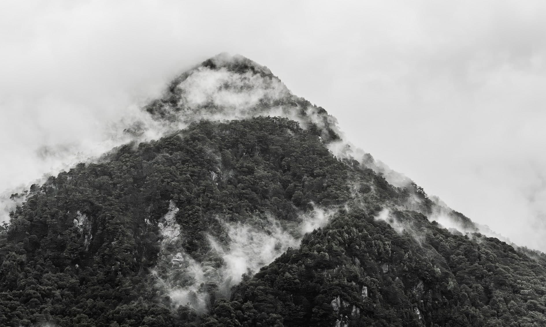 Cerro boscoso piramidal con nubes rozando la cumbre; blanco y negro. Tierra #S16, fotografía de Cristian Letelier, edición limitada