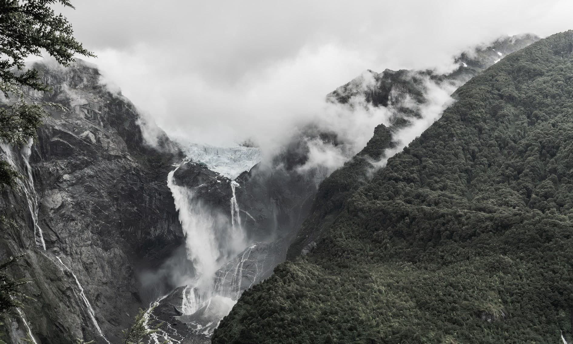 Glaciar colgante con cascadas entre paredes rocosas y bosque, nubes; color. Tierra #S19, fotografía de Cristian Letelier, edición limitada